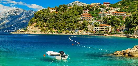 Beautiful coastline and beach with motorboat,Brela,Dalmatia regi Stunning summer landscape with Adriatic Sea,Biokovo mountains and wonderful bay - Brela beach