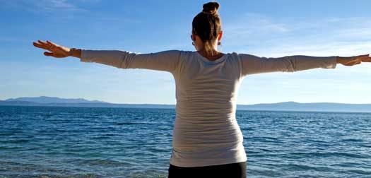 Young woman with open arms on beach Young woman with open arms on beach near blue sea