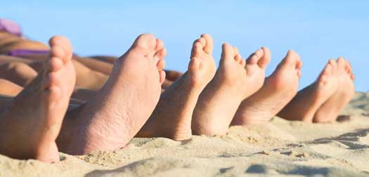Close-up Of Bare Feet Closeup of feet row lying in line at summer beach