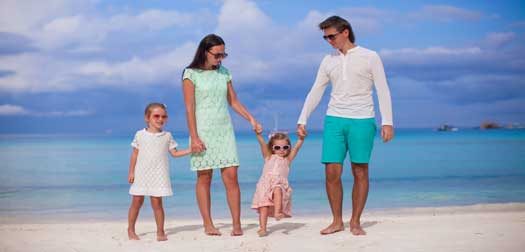 Family of four walking by the sea and enjoy beach Fashion family of four walking by the sea and enjoy beach all inclusive