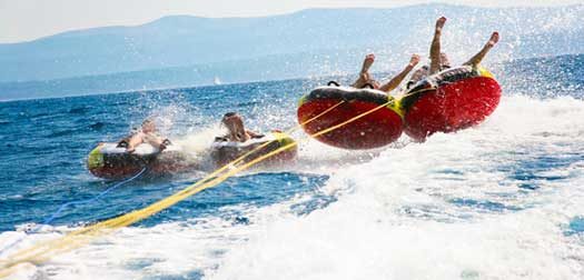 Younsters tubing Group of four bouncing up over wake on tubes on Croatian coast