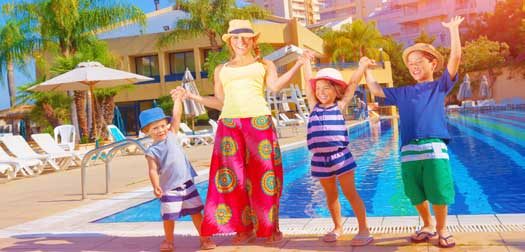 Happy family near pool Happy family having fun near pool on luxury beach resort, sunny day, all together raised up hands, enjoying summer holidays, happiness concept