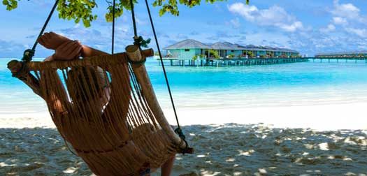 relaxation on paradise holiday girl young woman lying in a deck chair and looking at a tropical turquoise sea with bungalows on the water on holiday