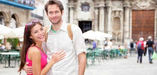 Cuba tourists in Havana Cuba tourists in Havana. Happy couple portrait during travel in Havana, Cuba, Asian woman, Caucasian man smiling happy on Plaza de la Catedral, Old Havana.