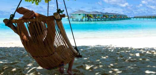 relaxation on paradise Caribbean girl young woman lying in a deck chair and looking at a tropical turquoise sea with bungalows on the water on the Caribbean Hawaiian Maldives