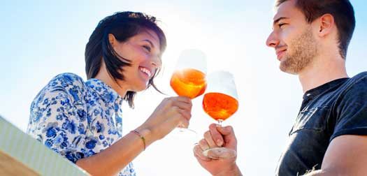 Couple talking while having spritz in a seafront Couple talking while having spritz in a seafront