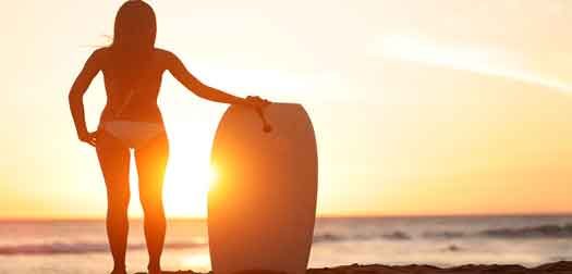 Water sport bodyboarding surfer woman beach travel Water sport bodyboarding surfer woman on summer beach vacation holidays travel. Surfing girl holding bodyboard looking at ocean sea and sunshine. Beach bikini babe. Kaanapali beach, Maui, Hawaii.