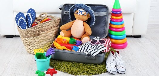 Suitcase packed with clothes and child toys.